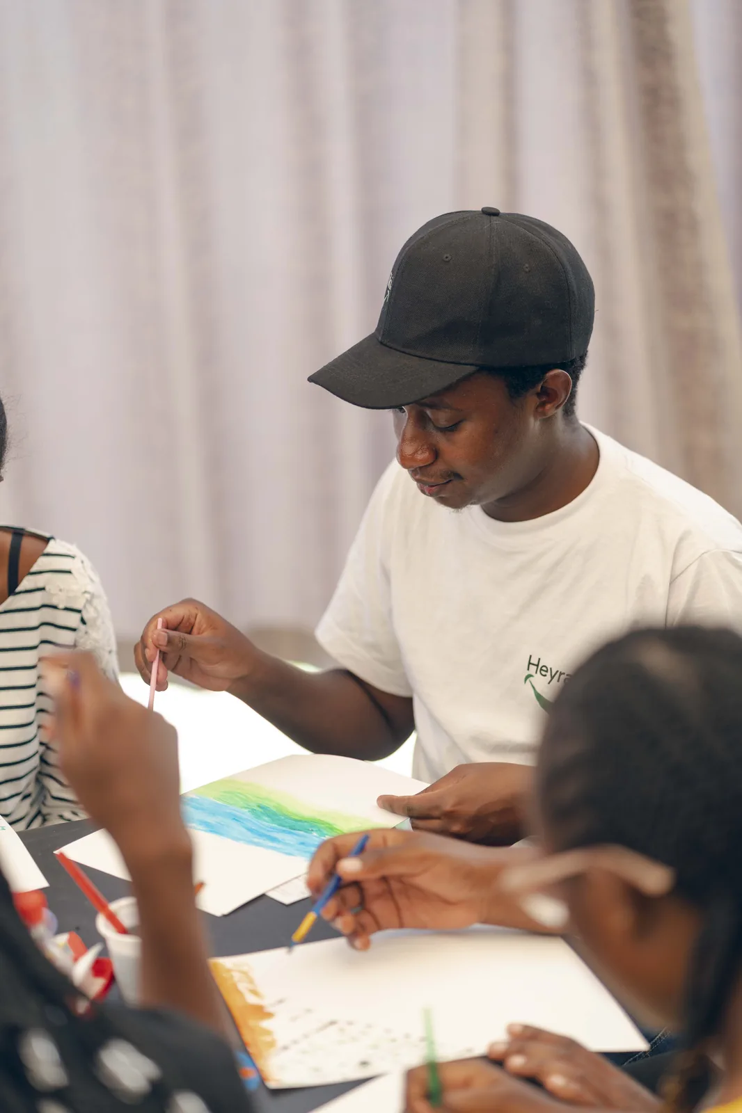 Moenga painting alongside young people during a community art session in Nairobi