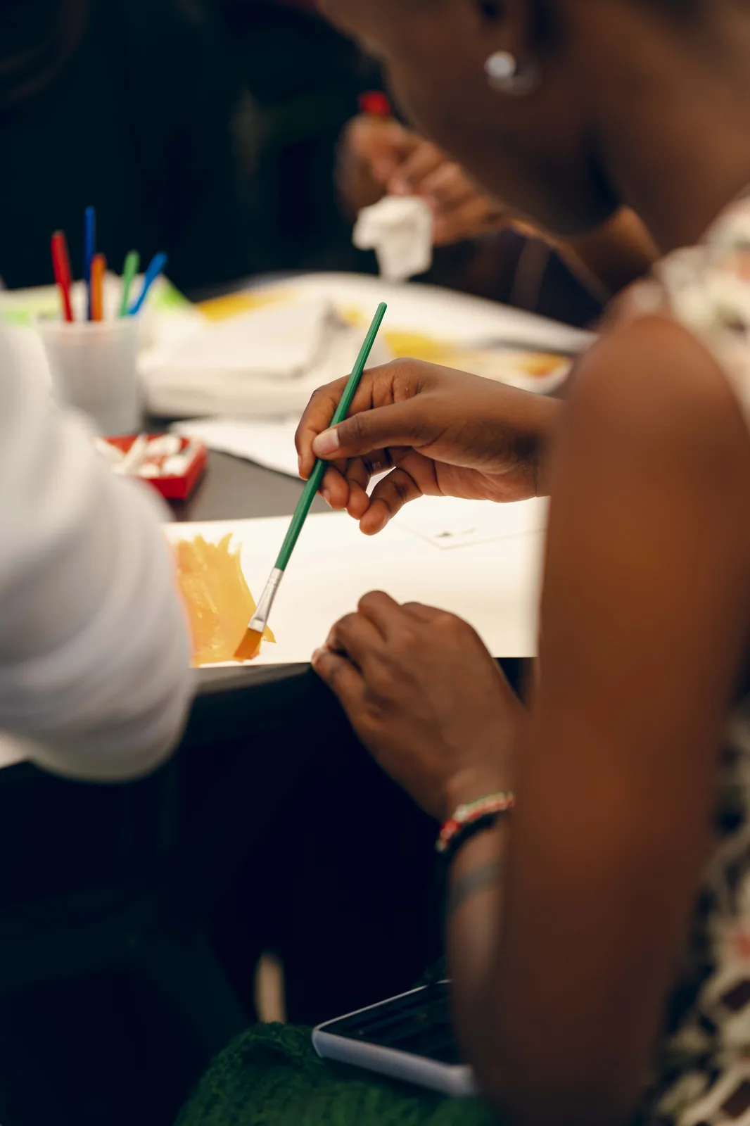 Hands at work around a shared table at a Heyrafiki art therapy session in Nairobi